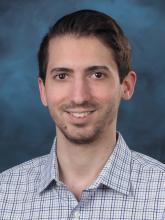 Professional headshot photo with a blue background